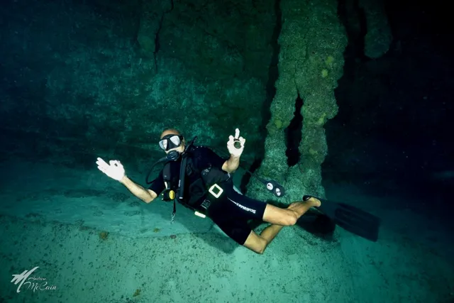 Diver underwater cavern — Isla Marisol Resort, Belize