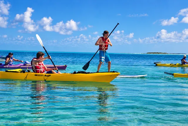Guests kayaking and paddleboarding on turquoise water